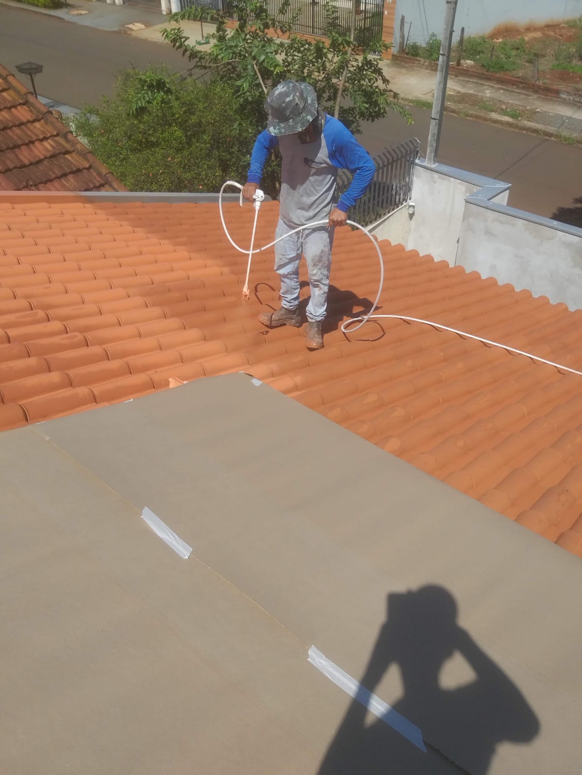 Telhado colonial sendo pintado na cor terracota com pistola airless